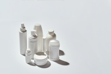 Set of different white tubes and bottles for hygiene, health and beauty isolated over white background with reflection