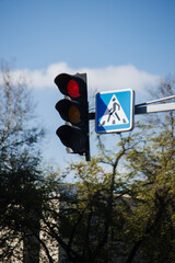 Traffic lights and pedestrian crossing sign in a city.