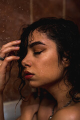 Attractive young naked woman under water drops