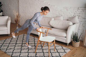 The girl performs exercises for the buttocks at home. Doing sports at home online. Healthy...