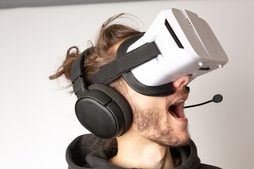 A close up of an unknown male wearing a VR headset and experiencing virtual reality. VR, virtual reality, gaming, e-sports concept