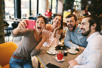 Group of Happy friends having making selfie in cafe