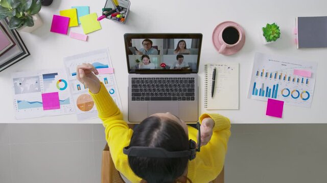 Top view of business woman talking about sale report in video conference. Asian team using laptop and tablet online meeting in video call.Working from home, Working remotely and Social isolation.