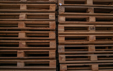 Wooden pallets for industrial and transport stacked in a large column on a warehouse