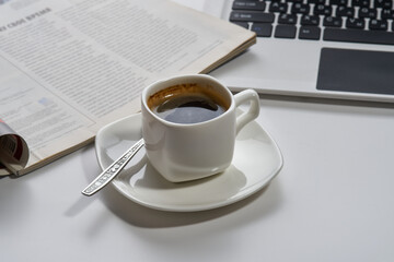 a cup of aromatic espresso coffee magazine computer on a white background. Selective focus.