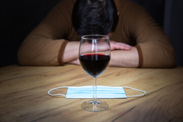 Office worker in cosplay costume of a cow. Guy in the funny animal pyjamas near the a glass of wine. Alcoholic addict, Lost job, unemployment concept, economic crisis. Depression and alcoholism.