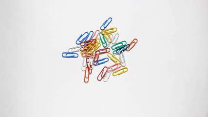 Obraz na płótnie Canvas Stationery paper clips of different colors on a white background.