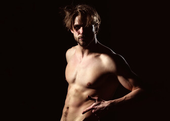 Fototapeta na wymiar Sexy man showing sexy muscular torso. Portrait of handsome man in studio on dark background.