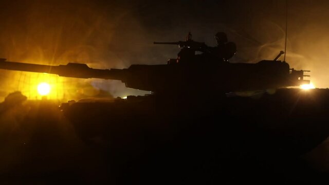 War Concept. Armored vehicle silhouette fighting scene on war foggy sky background at night. American tank moving in destroyed city. Slider shot