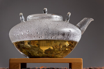 Glass teapot with tea leaves and water