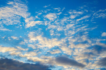 Blue sunny sky with white contrasting clouds for background