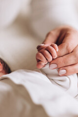 Close up of a person holding a hand of a baby