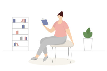 A woman sits on a chair and reads a book