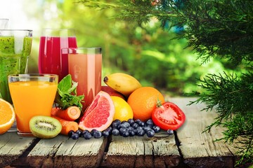 Composition of fruits and glasses of juice on desk