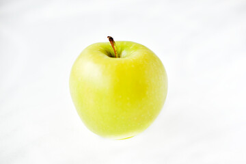 A bright green apple on a white background