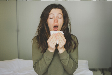 Sick young woman sneeze into paper napkin, blowing running nose reducing breathing relief...