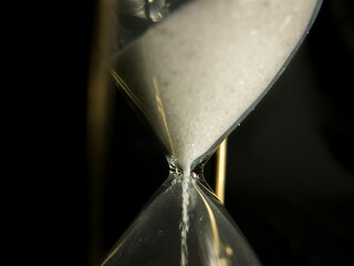 Hourglass with sand, time is running, on black backgroung