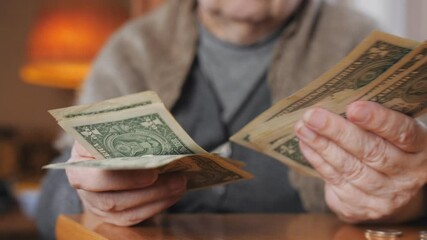 A woman with small bills in her hands counts the remaining savings. Economic crisis during the covid-19 pandemic. - Powered by Adobe