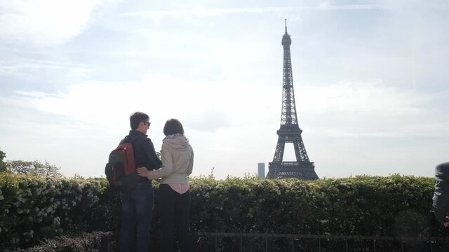 Man takes picture of Eiffel Tower with wife at journey