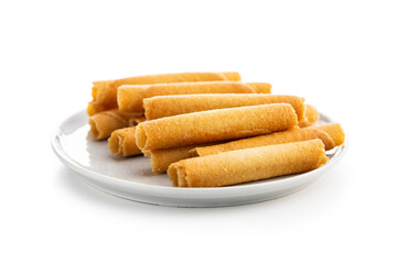 Sweet waffle tubes rolls on plate isolated on white background.