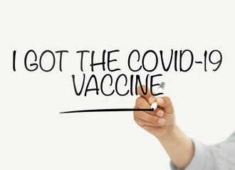Man writing "I got Covid-19 vaccine" on a transparent board