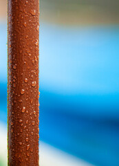 brown iron pipe with water-repellent coating without rust with water droplets