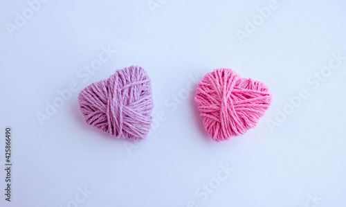 Two thread hearts hang on a white background. Holiday card, background. The concept of Valentine's Day, March 8, Mother's Day