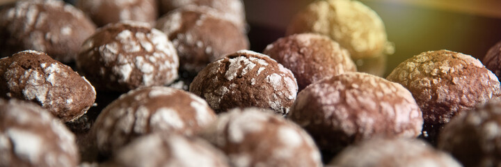 Cracked chocolate cookies with icing sugar on a pan