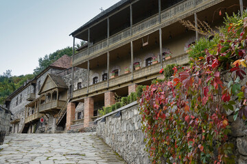 Traditional stone and wooden buildings, now used as shops, eateries, and a hotel, front a slate street in the Dilijan Historic Centre (Shaambeyan Poghots), Dilijan, Armenia.