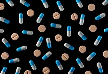 Blue white pills isolated on black background and texture, top view