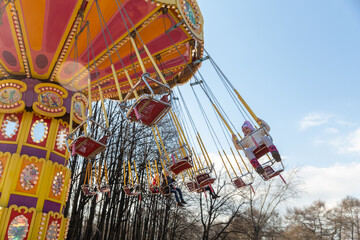A little girl spins on a carousel in the park