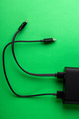 Black Power Bank with adapter for charging mobile devices. Power Bank close-up.