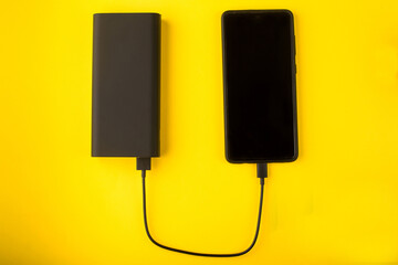 Black Power Bank with adapter for charging mobile devices. Power Bank close-up.