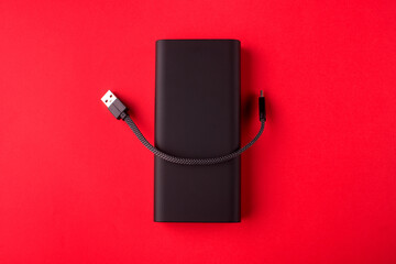 Black Power Bank with adapter for charging mobile devices. Power Bank close-up.