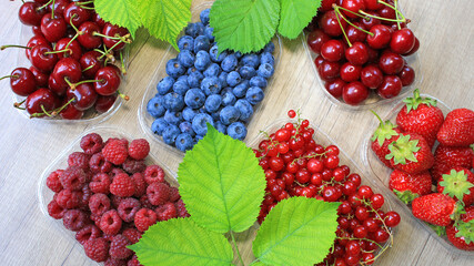 Fresh berries on wooden background, strawberry, blueberry, raspberry, blackberry, cherry and red currant