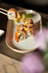 Girl eating rolls using traditional chopsticks, business lunch © Savory