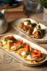 Assorted Russian pancakes with different fillings: red caviar, salmon, meat, chocolate