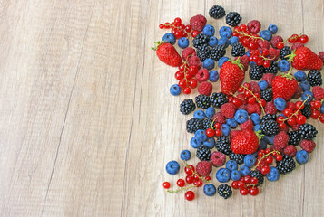 Fresh berries on wooden background, strawberry, blueberry, raspberry, blackberry and red currant