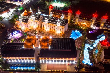 Side at night. Hotels and streets at night in Turkey. Illuminated resort at night in Antalya, Turkey aerial drone photo