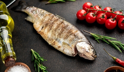 baked trout fish on a stone background.