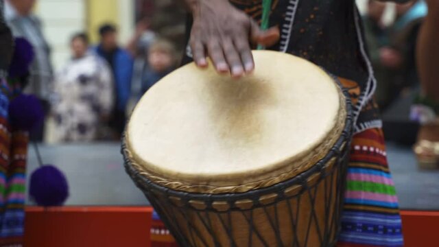 Man playing drum by his hands. Street performance using percussion instruments in slow motion