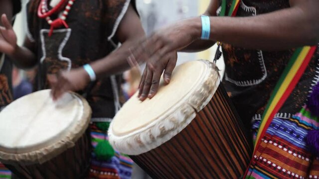 Man playing drum by his hands. Street performance using percussion instruments in slow motion
