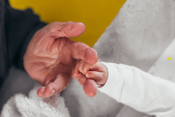 Senior hand and a hand of a baby
