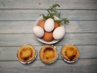 Prepared for a dessert with three belem cakes on an aged wooden table