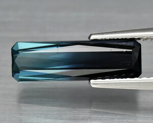 Natural gemstone bi-color tourmaline on the background Rectangular bi-color tourmaline