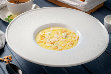 Corn porridge (polenta) with almonds and gorgonzola cheese in a white plate. Healthy breakfast