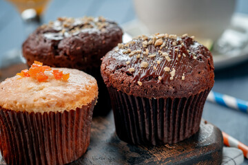 Chocolate and orange cupcake homemade with nuts on the table. Chocolate covered muffin close up