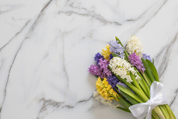 Bouquet of spring colored flowers of hyacinths. White marble background.