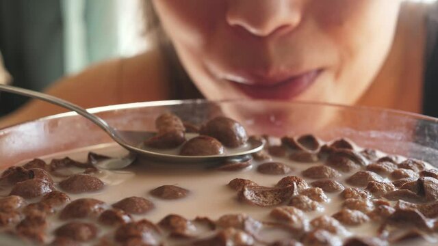 woman, mouth eating chocolate cereals in milk close