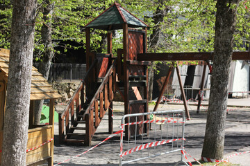 Fototapeta na wymiar playground for children closed on quarantine and repaired with protective tape 